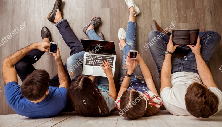 stock-photo-group-of-attractive-young-people-sitting-on-the-floor-using-a-laptop-tablet-pc-smart-phones-365329922